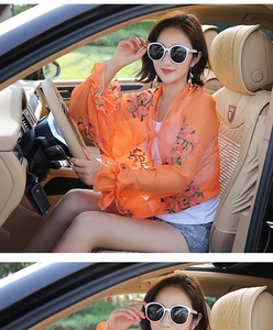 Detail of orange chiffon embroidered cardigan with ruffled cuffs for beach sun protection