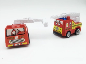 Detailed macro view of red cartoon toy fire trucks with personified eyes and white ladders