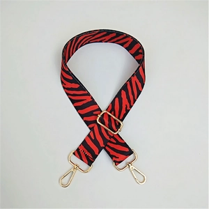 Detail of red and black zebra pattern replacement bag strap with gold metal hardware