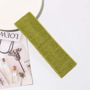 Close-up of grass green cotton terry sport headband with rich fiber texture on white
