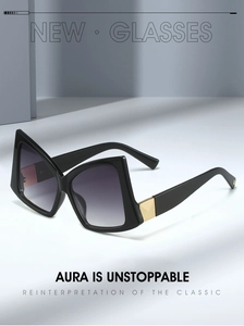 Detailed view of oversized butterfly sunglasses with black frames and gold metal hinge accents