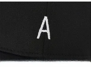 Gros plan sur la broderie lettre A blanche sur le tissu noir d'une casquette baseball