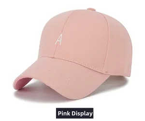 Détail d'une casquette de baseball rose en coton avec la lettre A blanche brodée dessus