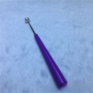 Detailed macro view of a diamond-coated bead reamer tool enlarging a white pearl hole
