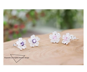 Close-up of pink and purple cherry blossom stud earrings with silver frosted finish