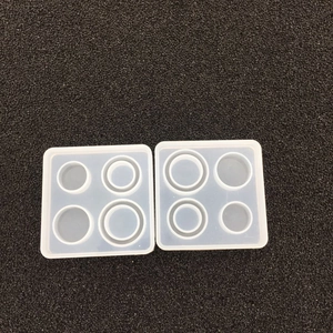 Macro shot of two semi-transparent square silicone molds with circular holes for DIY jewelry