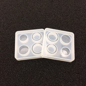 Macro detail of two transparent silicone resin molds with circular slots for jewelry DIY
