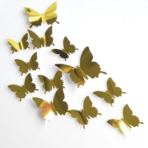 Macro detail of 3D metallic gold mirror butterfly wall stickers on white surface