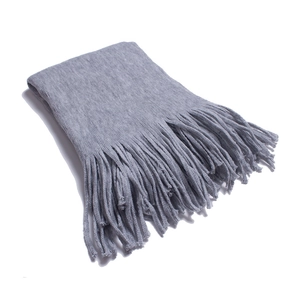 Detailed view of thick grey fringe scarf with soft knitted texture for winter warmth