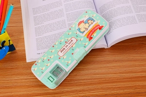 Detail of mint green cartoon pencil case with sharpener on a study desk with books