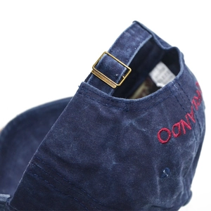 Detail of washed denim baseball cap with metal buckle and red Orlando embroidery