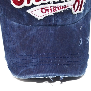 Macro detail of vintage washed denim baseball cap with distressed brim and Original embroidery