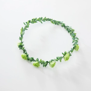 Detail of green foam rose headband with artificial leaves on a clean white background