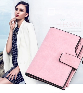 Detail of pink short wallet showing textured leather finish and elegant brand embossing