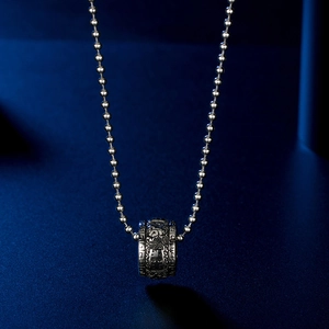Detail of silver beaded necklace with cylindrical lucky cloud lotus pendant charm