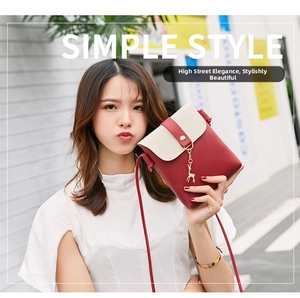 Close-up of mini PU crossbody phone bag with red-white contrast and golden deer charm