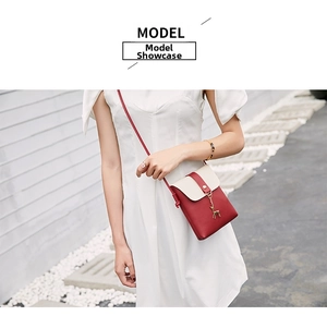 Detail of red and beige mobile phone crossbody bag with gold deer pendant on model
