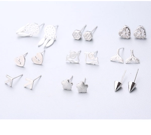 Dettaglio ravvicinato di un set di 9 paia di orecchini in argento con stelle e cuori