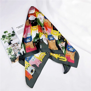Detail shot of a square silk scarf featuring a colorful cartoon cat pattern and smooth texture