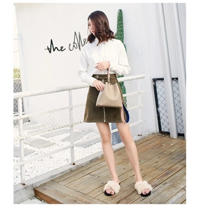 Chic beige leather bucket bag styled with a wide blue and pink contrast shoulder strap