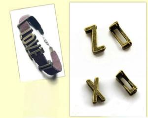 Detailed view of vintage silver alphabet slider beads on brown suede jewelry bands