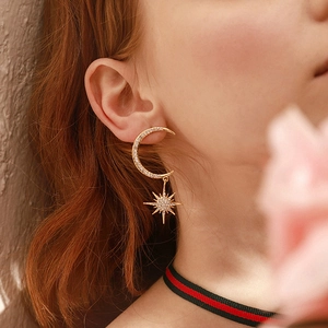 Macro shot of 925 silver crescent moon earrings with zircons and hanging star pendant