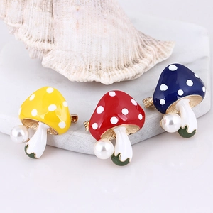 Macro detail of colorful mushroom enamel pins with pearls and polka dot patterns