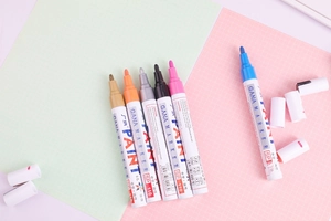 Detail of GANA SP 110 oil-based paint markers showing tips and branding in six colors