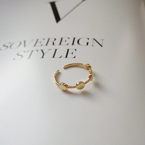S925 sterling silver gold plated twisted ring with round discs on aesthetic background