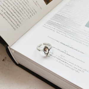 Vintage 925 sterling silver adjustable oval ring with beaded edges on art book background