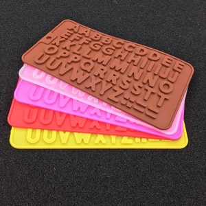 Gros plan de moules à alphabet en silicone souple pour glaçons et fondant en plusieurs couleurs