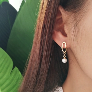 Minimalist 925 sterling silver gold irregular pearl drop earrings worn by a model