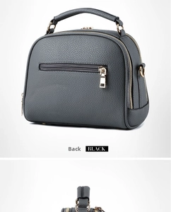 Detail view of the black lychee pattern leather handbag back with golden zipper and D-rings