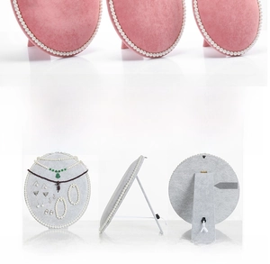 Detail of oval velvet jewelry board with pearl trim and foldable support stand