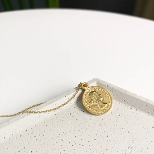 Macro view of gold-plated 925 silver coin necklace with Queen Elizabeth II relief