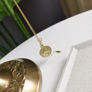 Close-up of gold-plated 925 silver coin necklace featuring an Elizabeth II portrait engraving