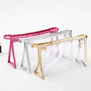 Three clear PVC cosmetic bags with gold, silver, and pink metallic borders and zippers