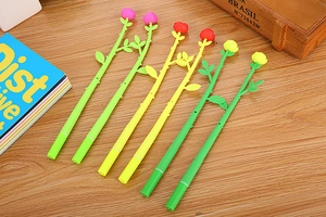 Close-up of 6 creative rose flower shaped gel pens in pink red and yellow on a wooden desk