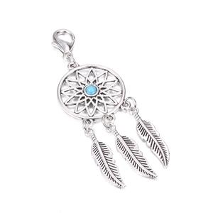 Detailed view of silver dreamcatcher keychain with blue bead and three feather pendants