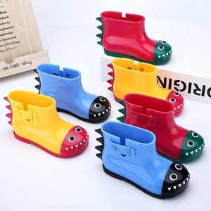 Detail of colorful dinosaur rain boots for kids featuring non-slip soles and 3D spikes