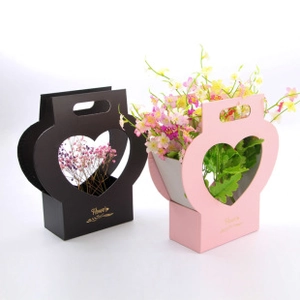 Detail view of foldable envelope flower gift boxes in black and pink with heart cut-outs