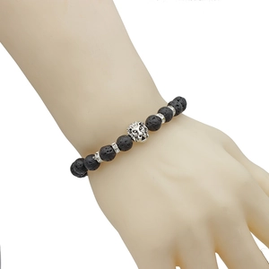 Black lava stone beaded bracelet with silver lion head pendant worn on a wrist