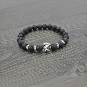 Lion head volcanic stone beaded bracelet with silver accents on dark wood background