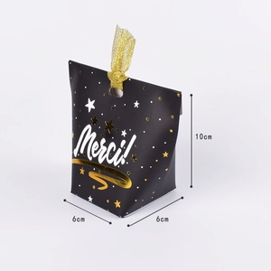 Elegant black and gold candy gift box with gold ribbon and Merci artistic lettering