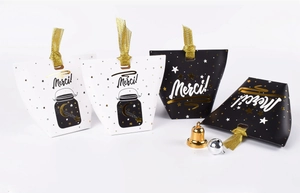 Detail of candy gift boxes with gold foil star patterns and elegant ribbon handles