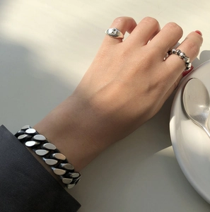 Detail view of retro 925 sterling silver ring set and vintage curb chain bracelet on wrist