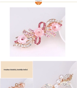 Detailed macro view of pink floral hair clip with rhinestones and pearl embellishments