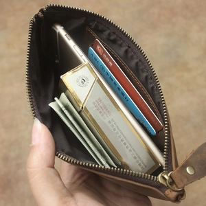 Detailed interior of vintage brown leather wallet holding phone, cash and cards
