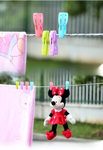 Close-up of colorful windproof clothes pegs with hooks on a drying line outdoors