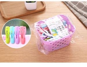 Detail of 30 colorful plastic clothespins with a purple storage basket on wood